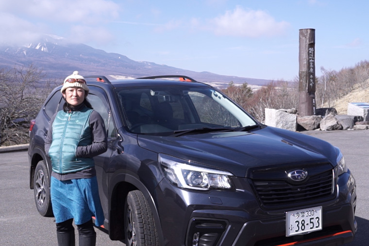 野辺山高原平沢峠にて、新型フォレスターX-BREAKの前に立つ山岳カメラマンの「アヤ」さん